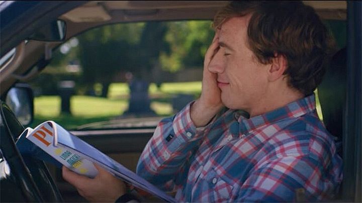 Connor O'Malley in I Think You Should Leave looking mesmerized at his porno mag with his hand on the side of his face