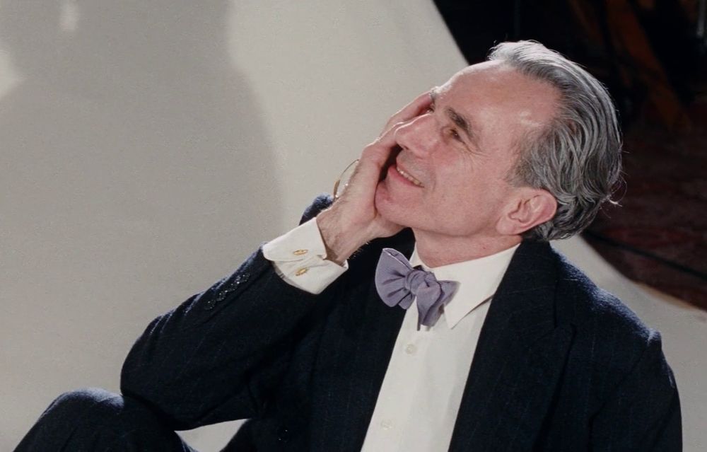 Daniel Day-Lewis in Phantom Thread looking mesmerized by his muse with his hand on the side of his face