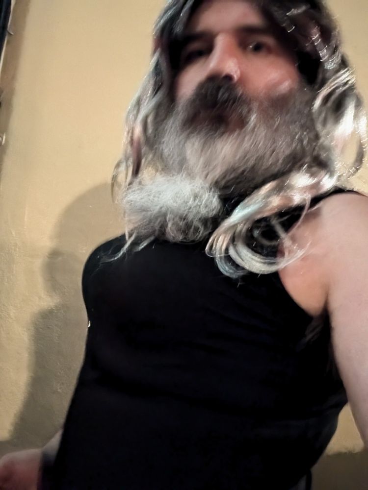 Nastasia Smokewalker going out in a black dress with silver and black wig with a Grey and brown beard. 