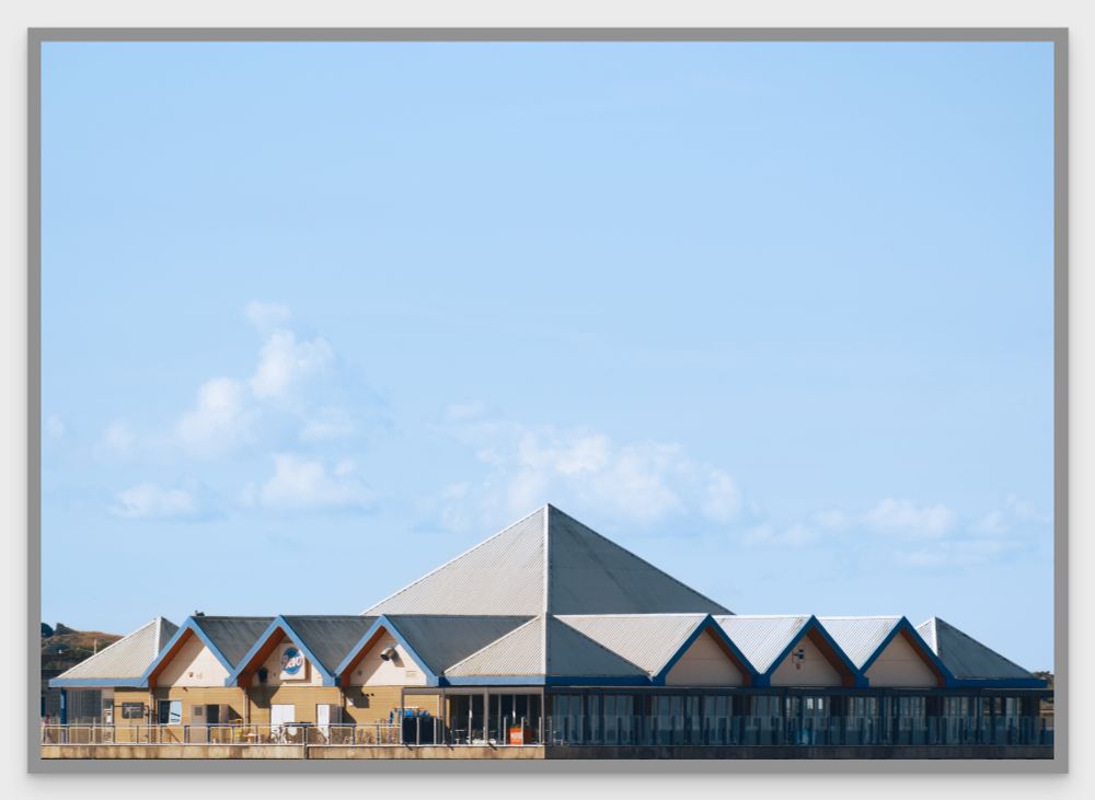 This is a photograph of Revo Kitchen's building, on the seafront at Weston-super-mare in Somerset, England.

The building's roof is made up of a large central pyramid, with longer triangular rows jutting out to the edge of the building. The unusual roof design makes for a striking appearance in the early morning sun.