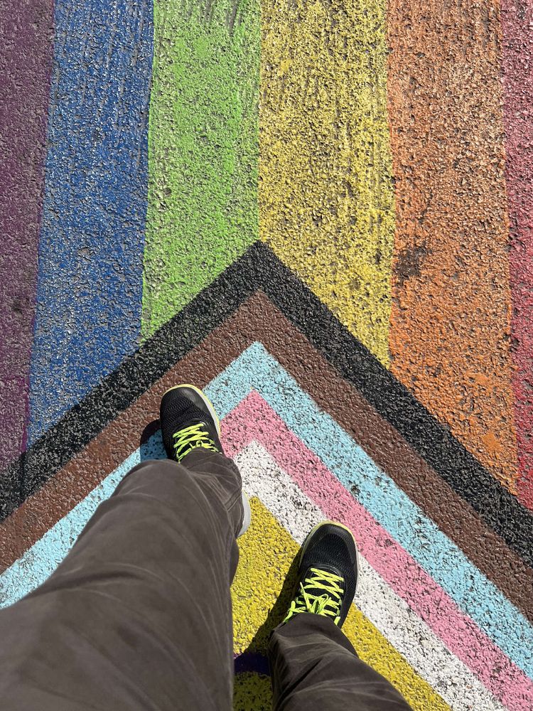 The OP is walking on a painted pride flag on the street. 