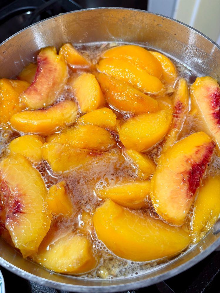 A pot full of peaches and syrup