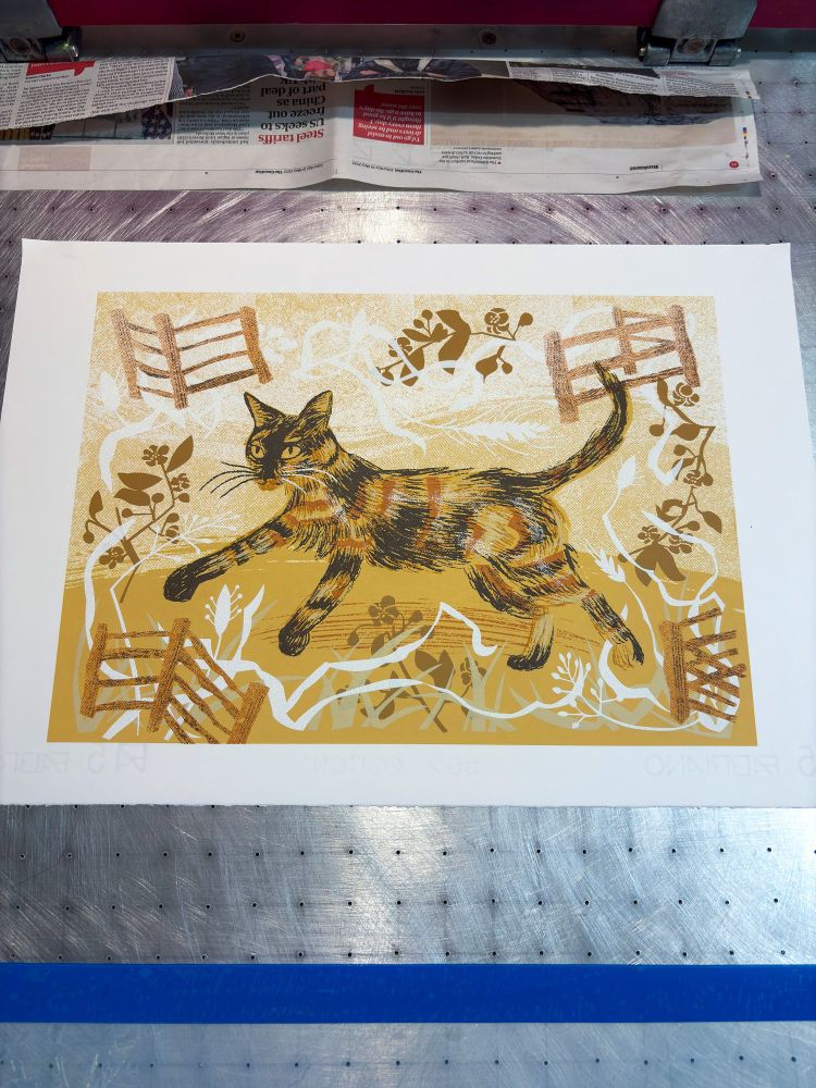 A screenprint in yellow, orange, brown, of a tortoiseshell cat called Frida.