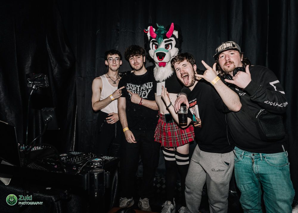 5 individuals, one wearing a fursuit head, posing for the camera - the DJs for FNNY 2025