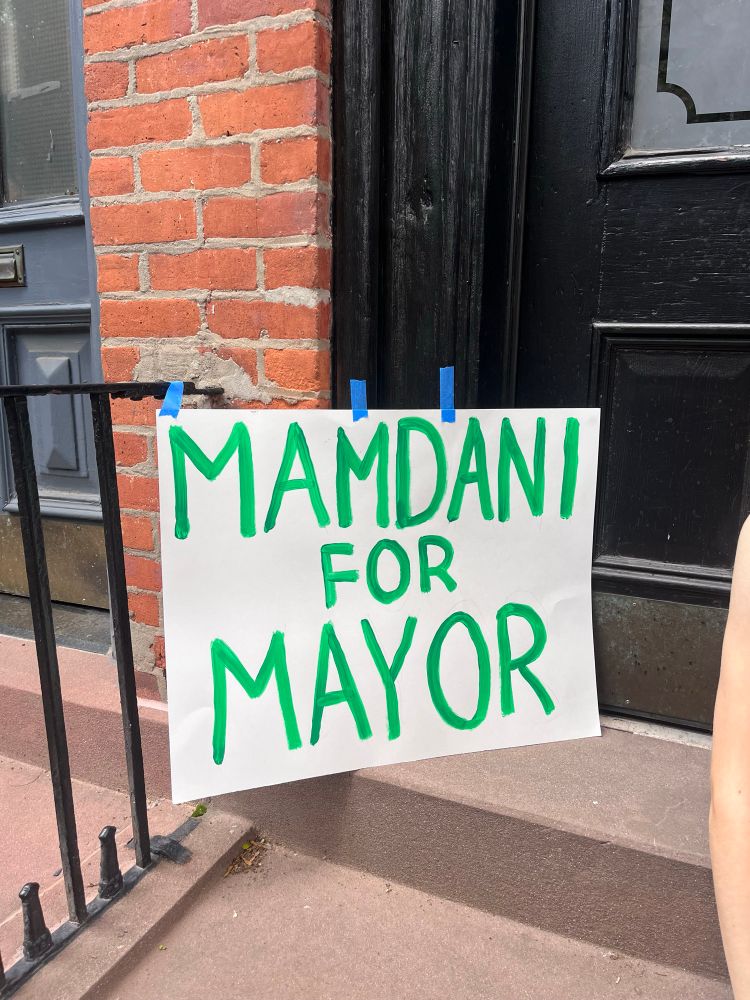 Sign on a door of a building says “Mamdani for Mayor”