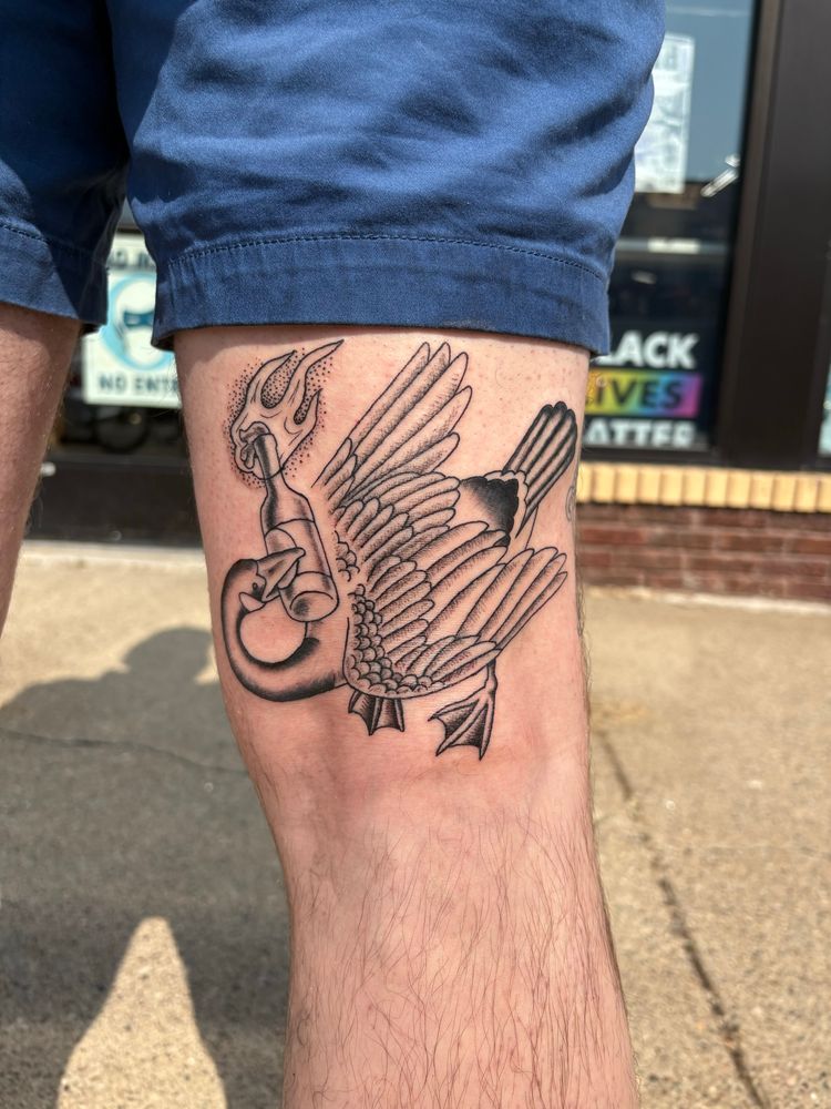 Tattoo of a goose holding a molotov cocktail in its beak