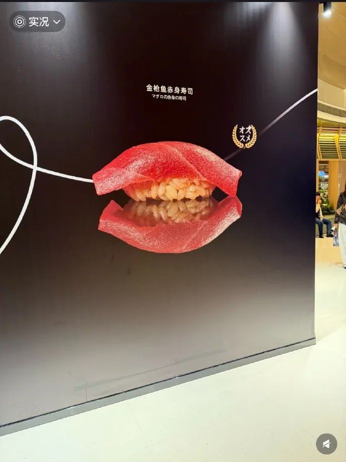 An advertisement for tuna sushi in a shopping mall resembles a gaping maw, creating an eerie effect.