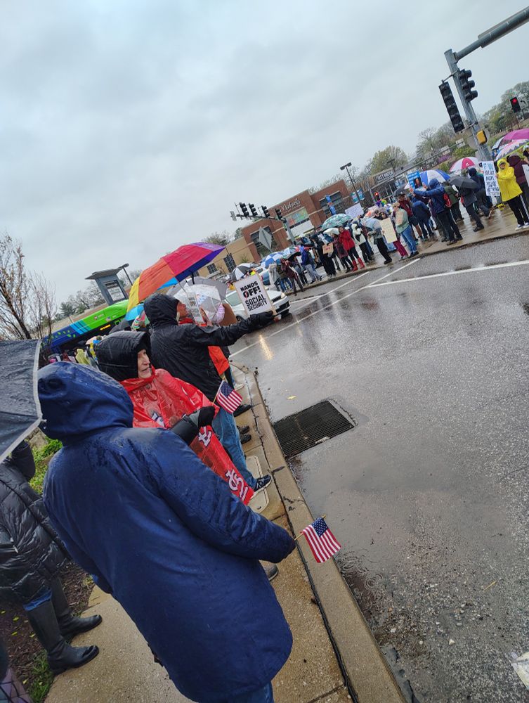 Hundreds of people showed up on a rainy day to demonstrate at a busy shopping center to fight Trump