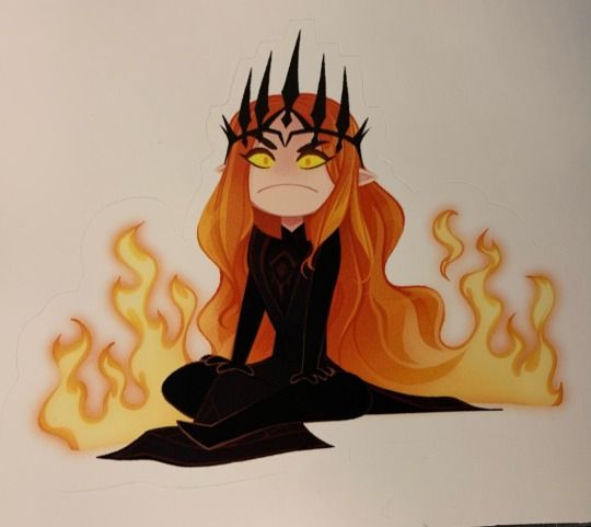 Sticker is Fiery Eye by Arianwen44 on RedBubble, and it shows a cartoony Sauron in his fair form, in all black with a spiky crown, yellow eyes, and red-orange hair that falls to the ground and becomes flames. He's frowning in great displeasure.
