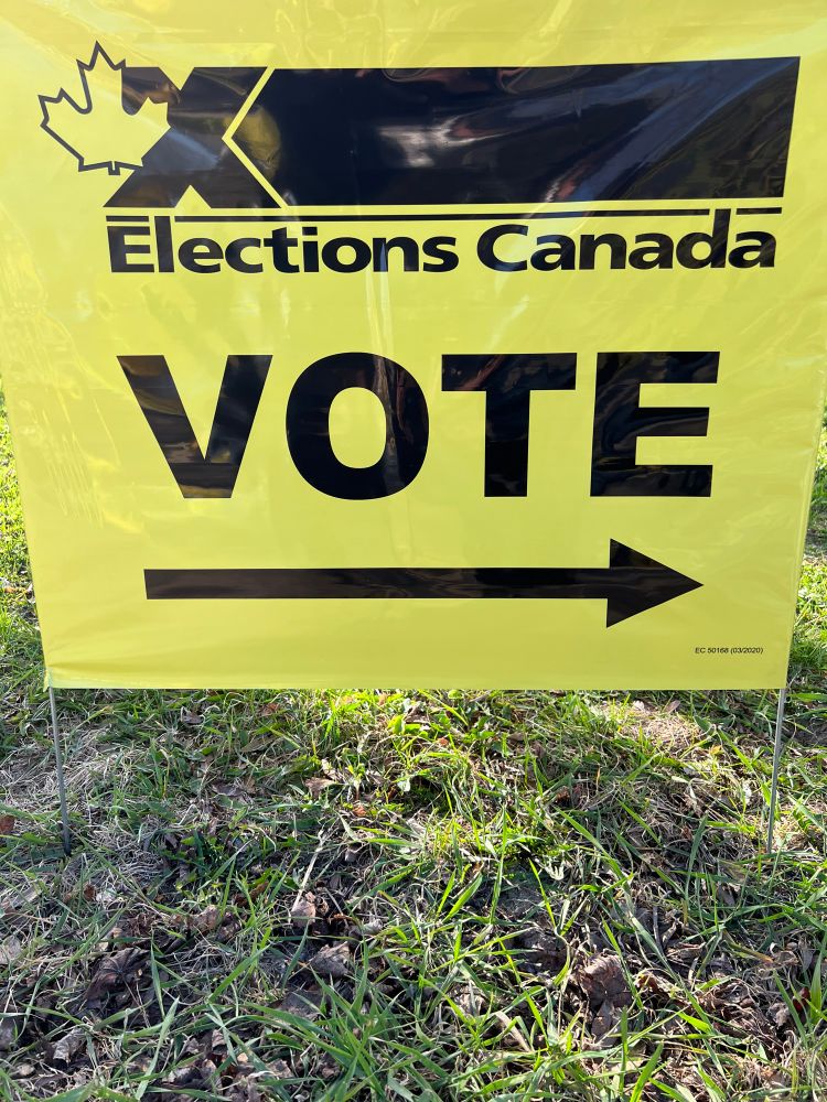 A photo of an Elections Canada voting sign that points to the right towards the voting station.