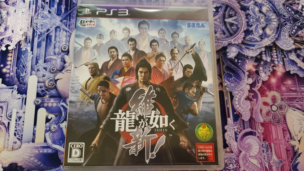 A copy of the PS3 version of Ryu ga Gotoku Ishin sitting on a desk mat