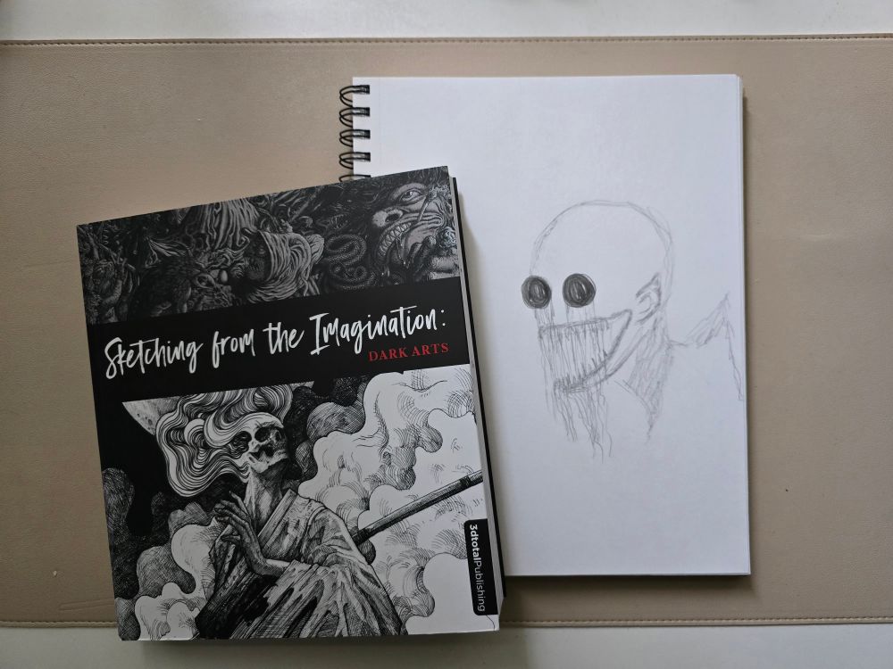 Left: book titled, Sketching from the Imagination / Right: rough outline sketch of a monster with blacked out eyes and a sharp edge to it's back (mainly shoulders up)