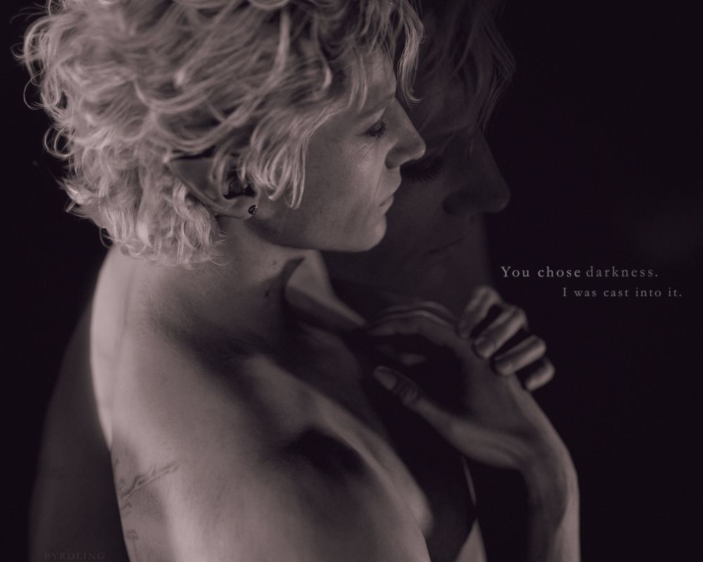 A photo of Astarion from Baldur's Gate 3. His eyes are closed and his hands are cupped near his chest. There is a double exposure effect and the image is in a monochrome style. There is text to the right of his hands that reads: You chose darkness. I was cast into it. 