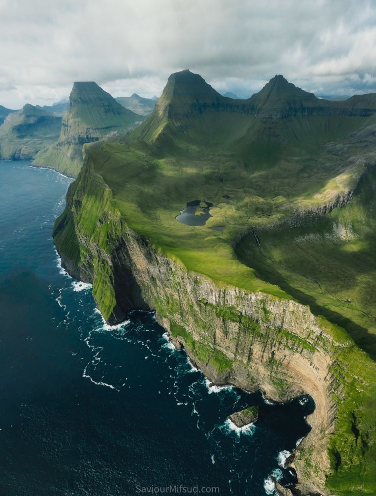 Cliffs of Streymoy island, in the Faroe Islands with lush greens, sea stacks, mountains and lake