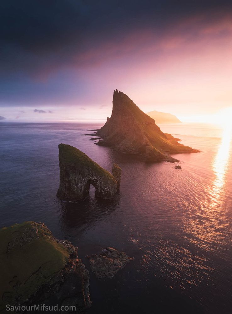 Birdseye view of the seastacks drangarnir, islet tindhólmur and Mykines island in the background with an incredible Sunset light and colours.