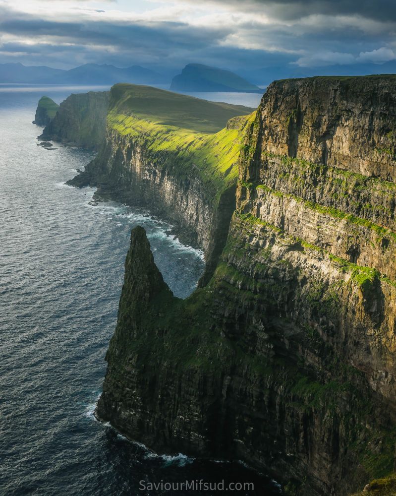Liraberg cliffs at Sandoy, Faroe Islands. Sunlight shining on the cliffs after heavy rain.