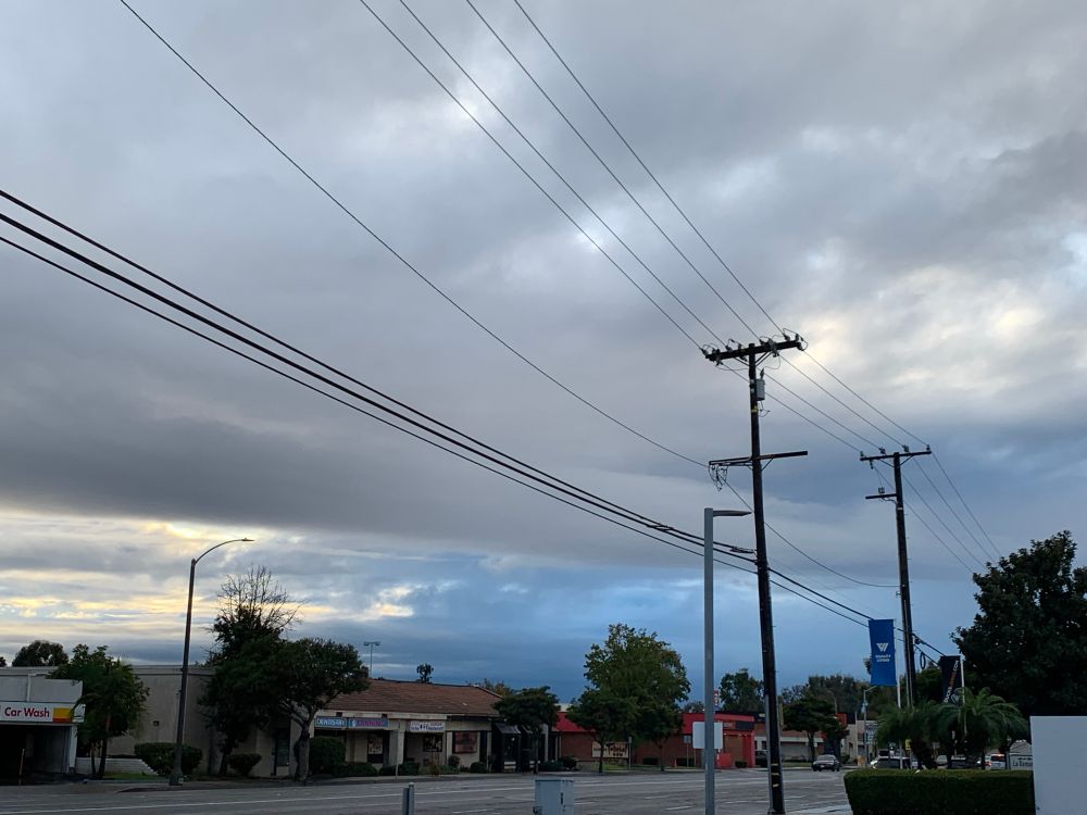An overcast sky, where a distant part of the clouds has a blue glow to it