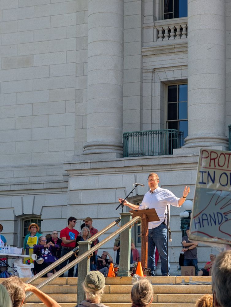 Ben Wikler speaking in front of the Wisconsin State Capitol building 