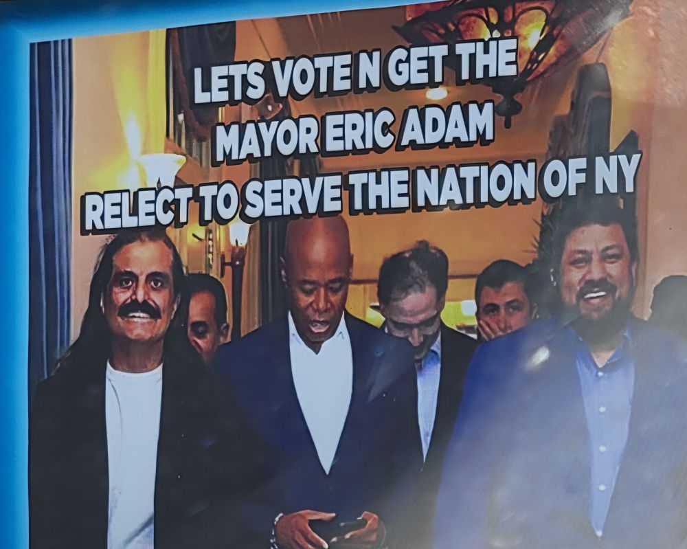Eric Adams looking at his phone while surrounded by SE Asians with the caption (verbatim) 

LETS VOTE N GET THE
MAYOR ERIC ADAM
RELECT TO SERVE THE NATION OF NY