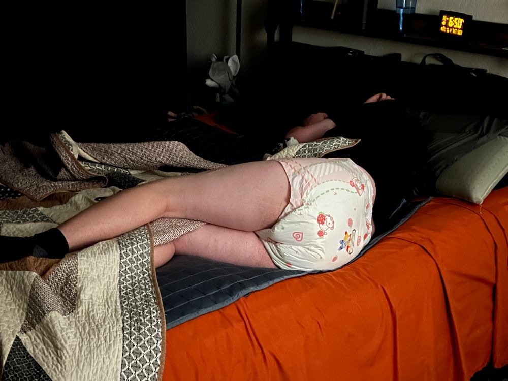 My gf laying in bed with her diaper exposed