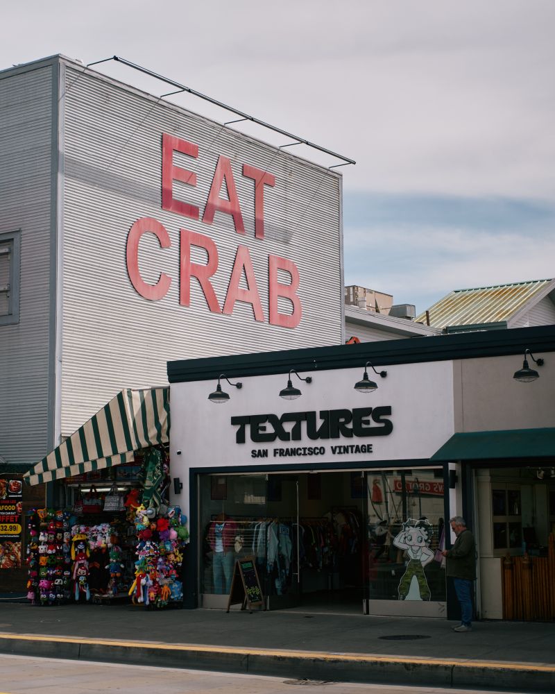 A photo with textures in the foreground and a sign saying eat crab in the background 
