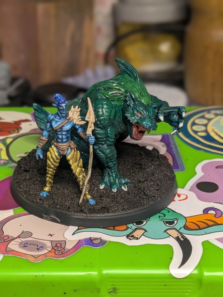 A DND model of a sea elf and magical lion-shark hybrid monster.