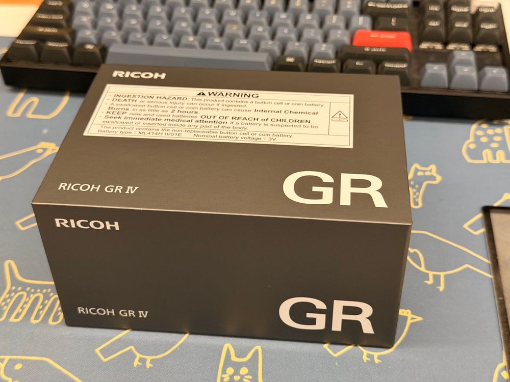 Ricoh GR IV box on the desk.