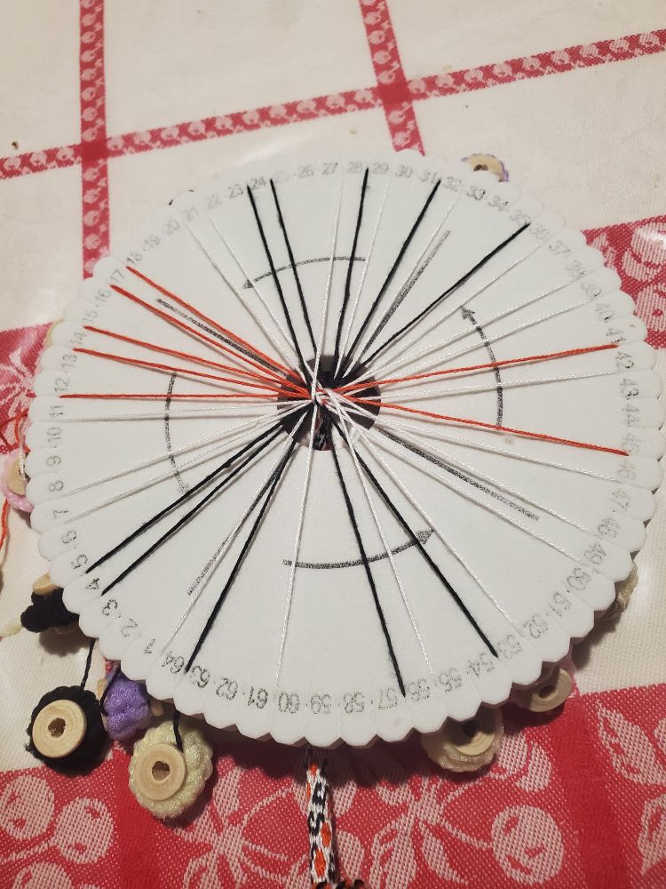 Disque pour faire du kumihimo qui est une technique où on fait passer des fils les un par dessus les autres dans un certain sens pour tresser une corde
