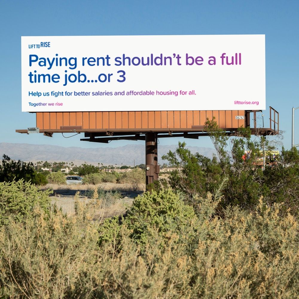 Billboard that reads “Paying rent shouldn’t be a full time job…or 3. Help us fight for better salaries and affordable housing for all.” Together we rise. Visit lifttorise.org. 