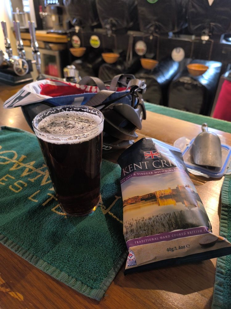 Pint of bitter and a packet of salt and vinegar crisps on a bar at the Royal Oak in Fritham, Hampshire.