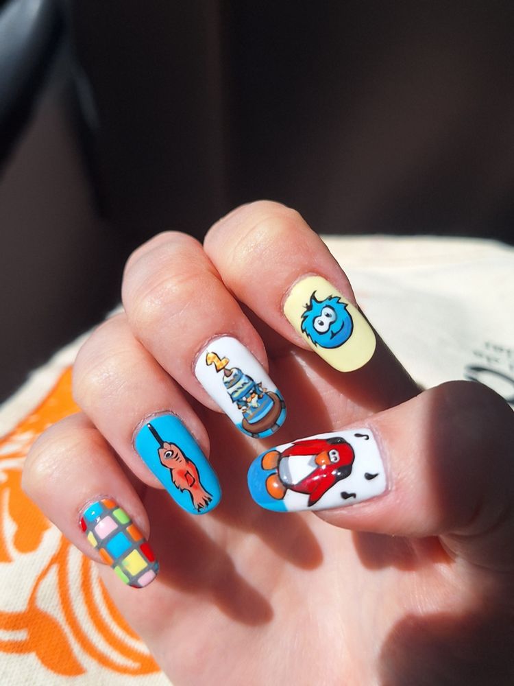 minha mão virada com a palma para a câmera, os dedos dobrados pra dentro pra mostrar as unhas pintadas com temática de club penguin. do dedo mínimo para o dedão, as ilustrações são: a pista de dança colorida da balada, o peixão mullet do jogo de pesca em posição já pescado, um bolo de vários andares com uma vela de 2 no topo, um puffle azul em um fundo amarelo pastel, um pinguin vermelho escutando música com um headfone cercado de notas musicais