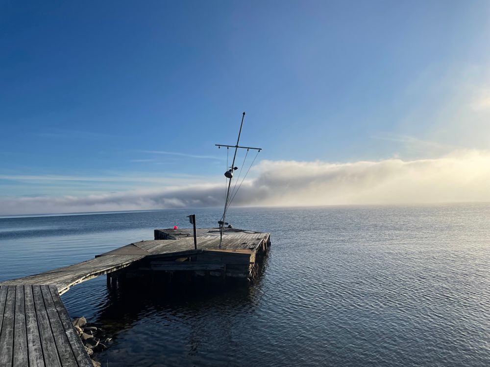 Brygga i motljus med dimbank vid horisonten 