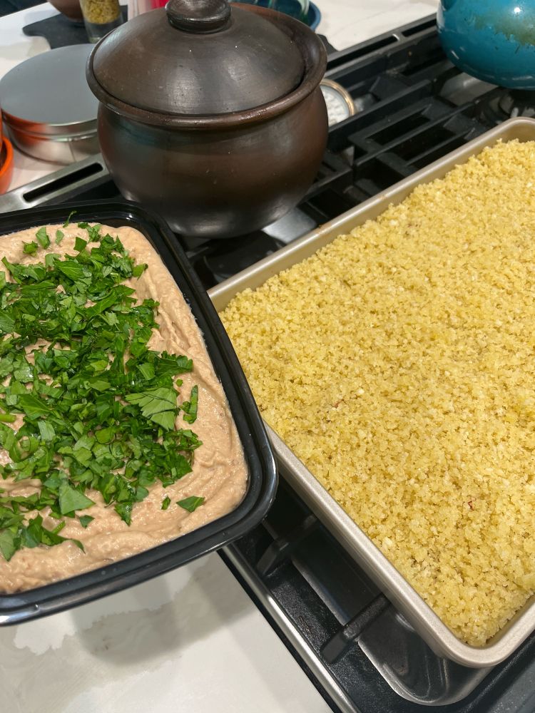 Bean dip with cilantro and parsley on the top, shown with a veggie cassoulet covered in bread crumbs.