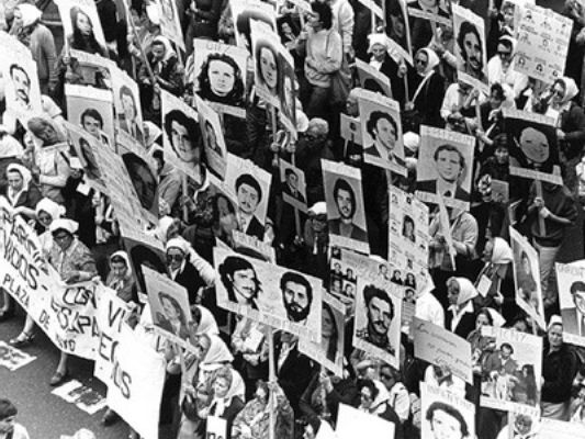 Mothers of disappeared people during three last dictatorship in Argentina holding posters of their kids’ faces during one of their typical marches
