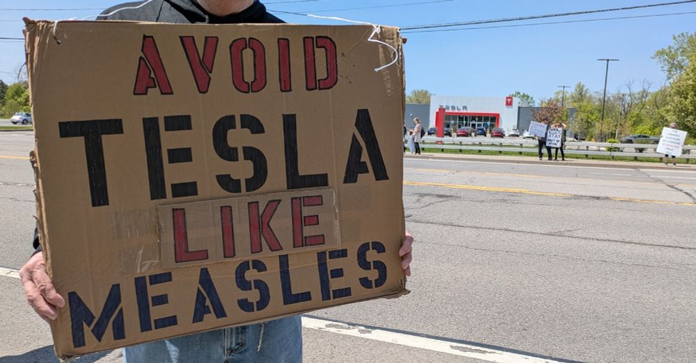 Protest sign that reads: Avoid Tesla like measles 