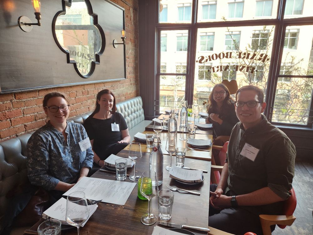 Photo of a group of four people sitting at a table in a restaurant. 