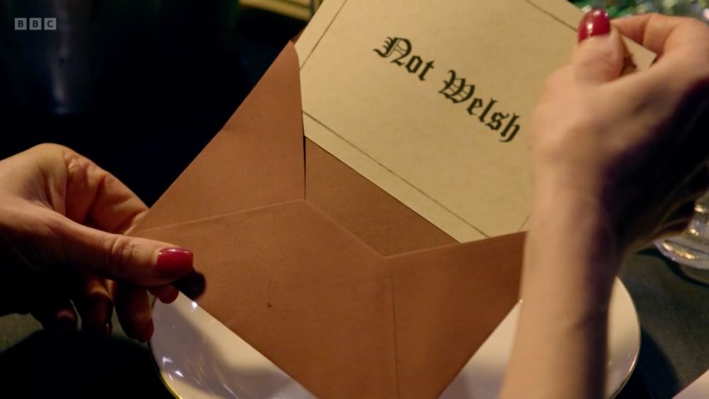 A piece of paper being taken out of an envelope. The paper says "Not Welsh"