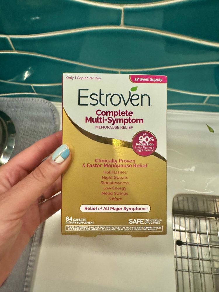 A hand holding a box of Estroven tablets