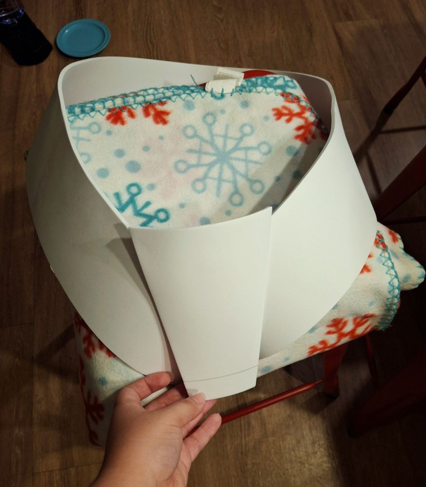 Image of the belt shape and buckle shape made of EVA foam perched on a stool. 