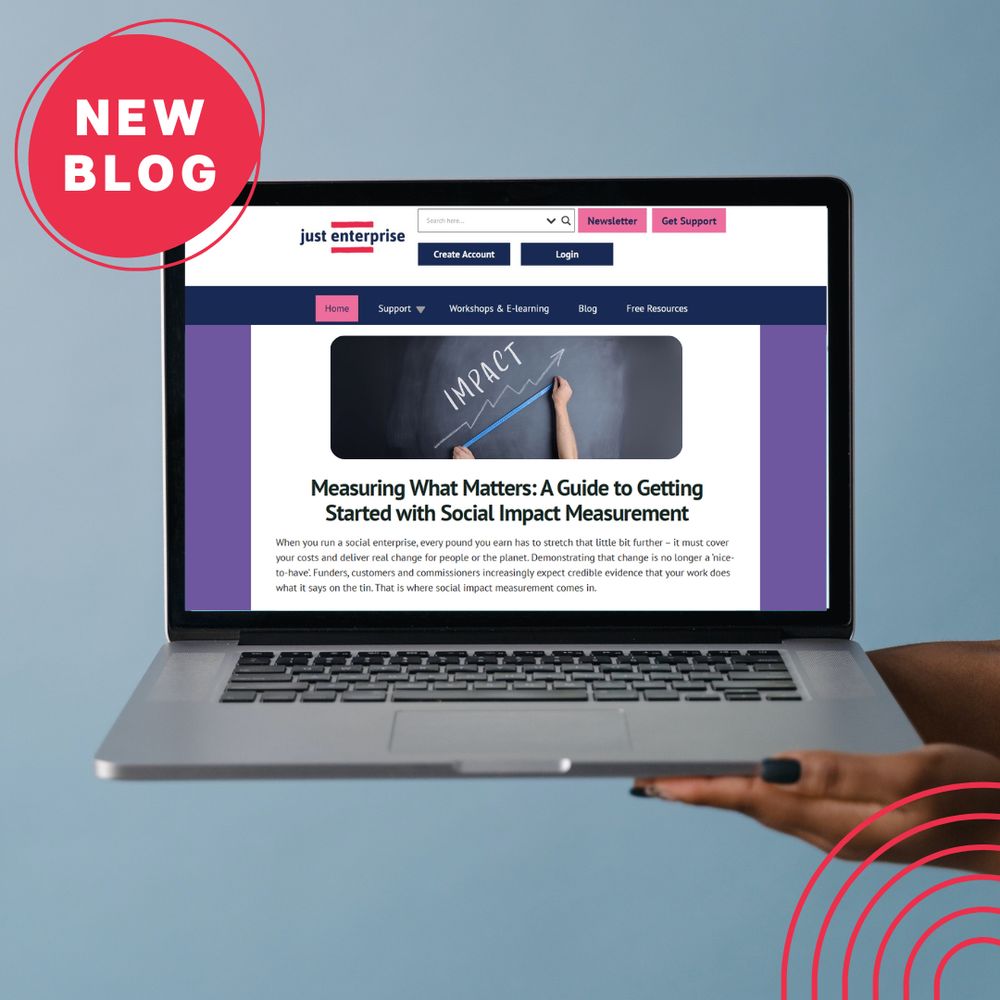 Laptop screen displaying the Just Enterprise website with a new blog titled "Measuring What Matters: A Guide to Getting Started with Social Impact Measurement", held up by a hand against a blue background. A red "New Blog" badge appears in the top left corner.