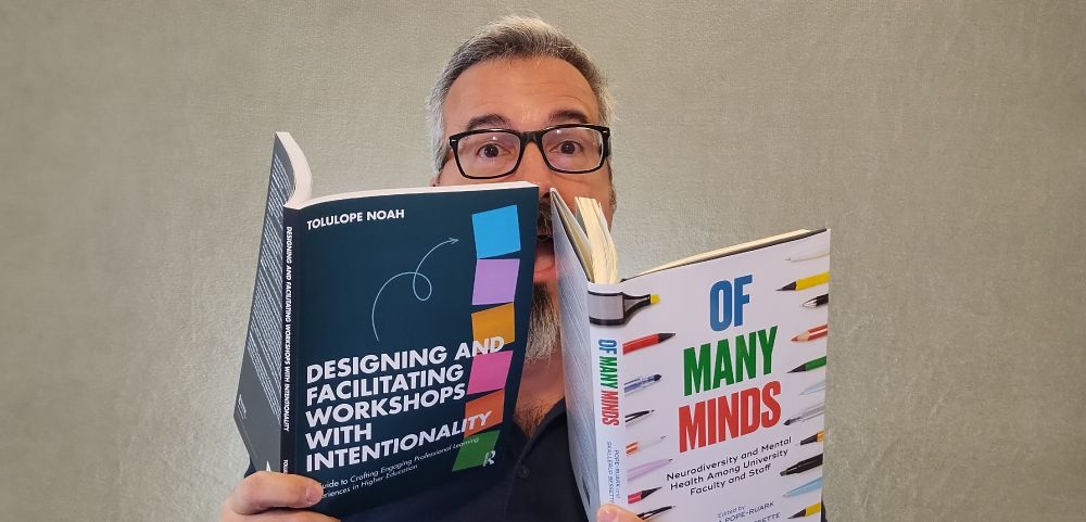 Tom Tobin reads two books at the same time: *Of Many Minds* and *Designing and Facilitating Workshops with Intentionality.*