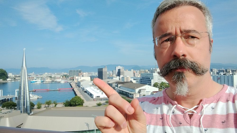Tom Tobin points to a spire in a port city.