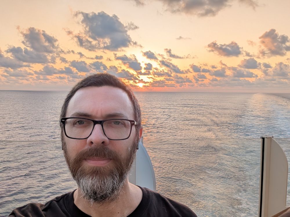 Mathman at sea with a sunrise over his shoulder.
