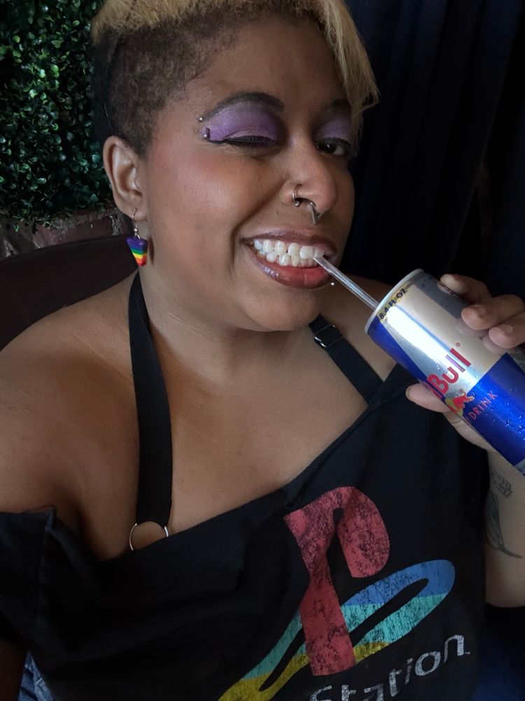 Bianca is drinking a Red Bull while showing her teeth