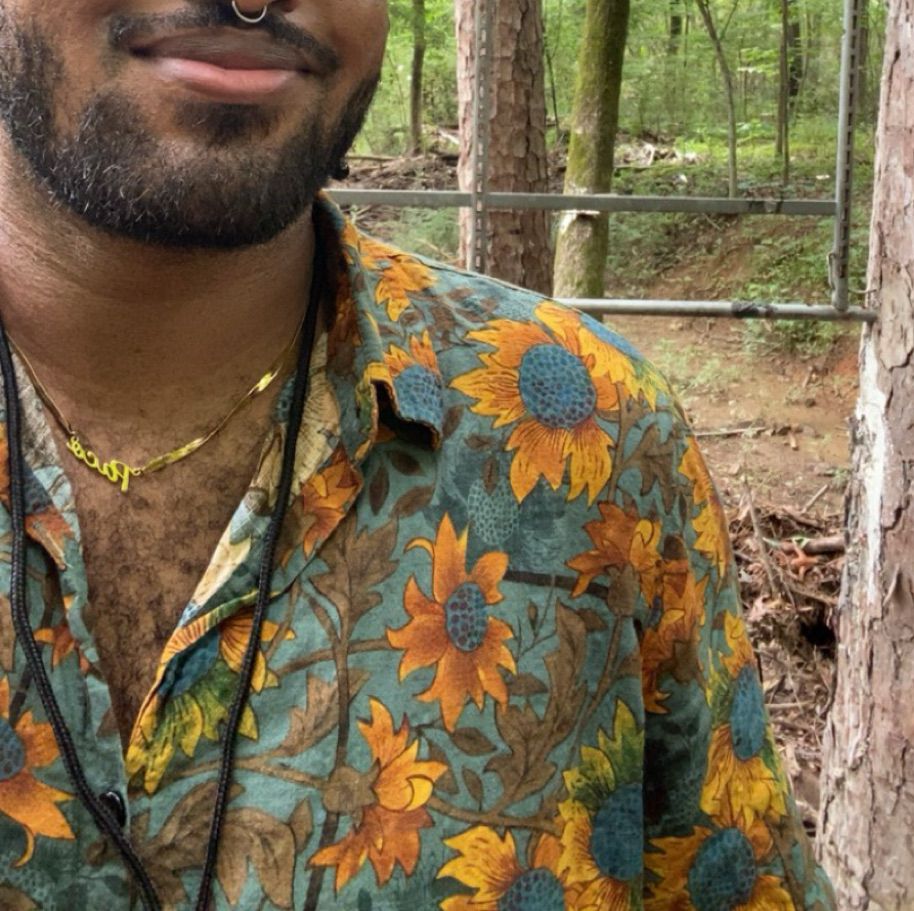 Me in a cute lil sunflower print, short sleeve, button up. (I’m in the woods)