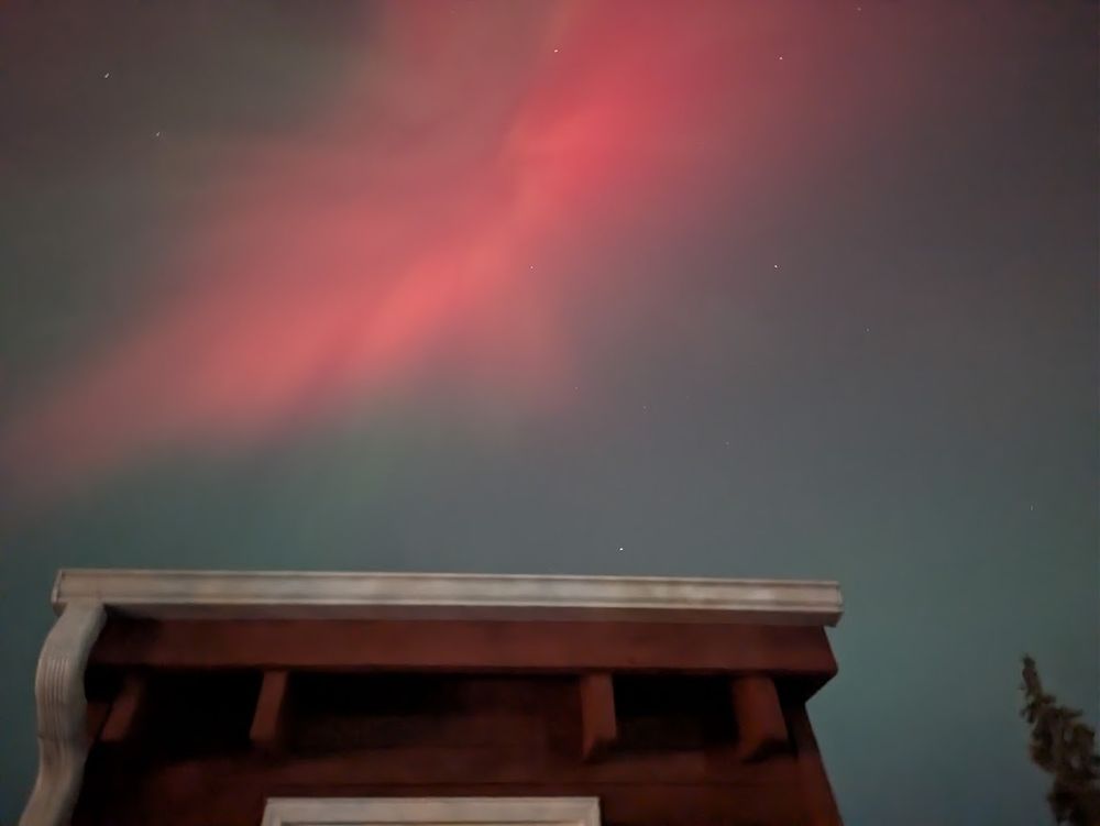 A twisting pink streak over part of a house.