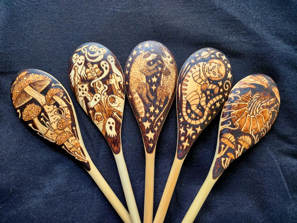 Shows five woodburned spoons