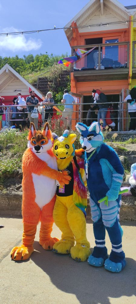 Rik (fox), Azzy (yellow dragon) and Syfy (blue red panda) pose for a photo 
