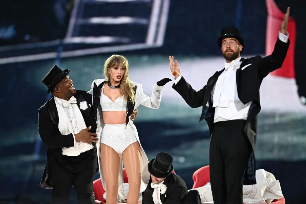 Kam, Taylor, and Travis on stage at the eras tour 