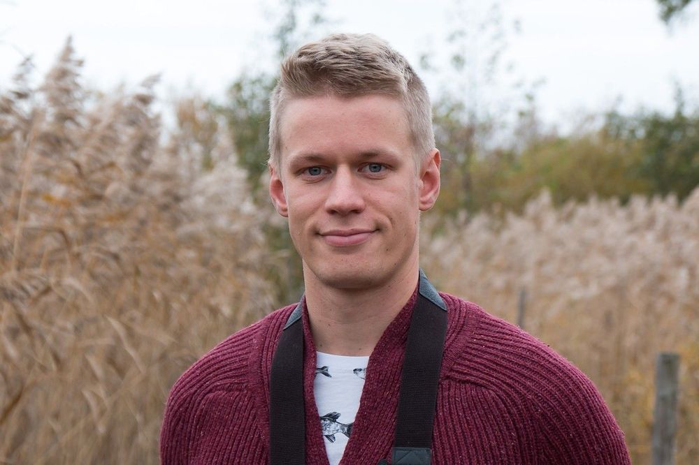 Patrik Lauha standing in front of tall reeds.